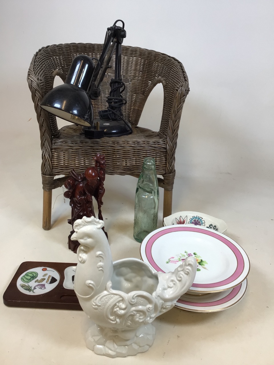 A childs wicker chair, a lamp, a Codd bottle, ceramics, a carved oriental figure