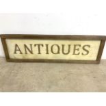 A wooden antiques sign.