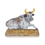 A Dutch Delft polychrome figure of a recumbent cow, 18thC, H 11,5 - W 16 cm