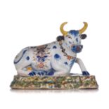 A Dutch Delft polychrome figure of a recumbent cow, 18thC, H 11,5 - W 16 cm