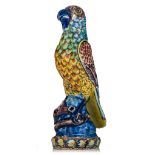 An exceptional and colourful Dutch Delft polychrome figure of a parrot sitting on a branch, 18thC, H
