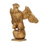(BIDDING ONLY ON CARLOBONTE.BE) A gilt limewood sculpture of an eagle on an orb, 18thC, H 39 cm