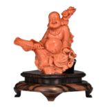 A Chinese red coral figure of a prosperous smiling Budai, late Qing, H 19 - W 16,1 cm - Weight 809 g