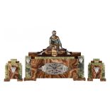 An Art Deco onyx marble three-piece clock set with on top a patinated spelter lady playing with a ca
