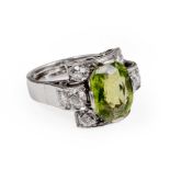 An 18ct white gold ring set with eight brilliant cut diamonds and an oval cut green tourmaline