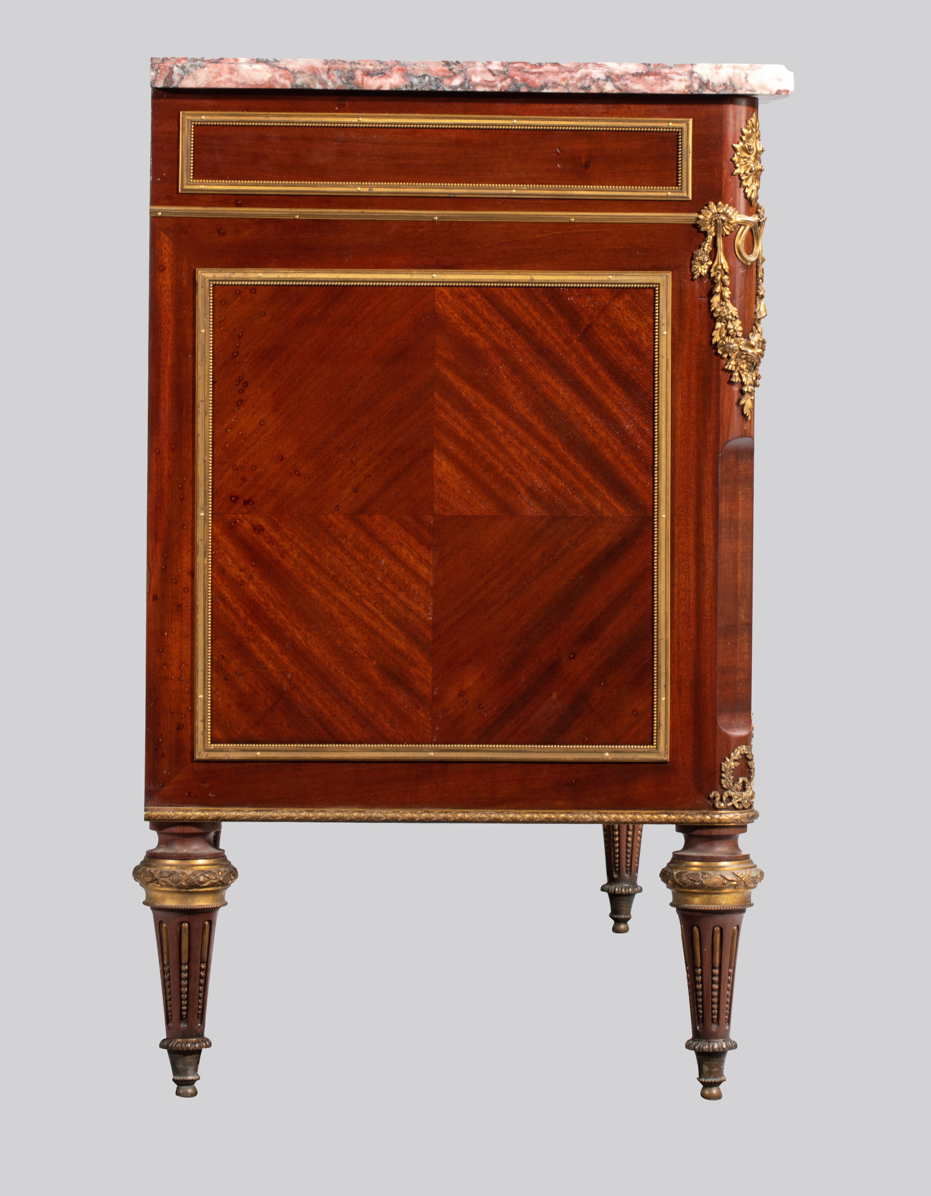 A Louis XVI style mahogany veneered commode with gilt brass mounts and marble top, H 89 - W 134 - D - Image 7 of 8