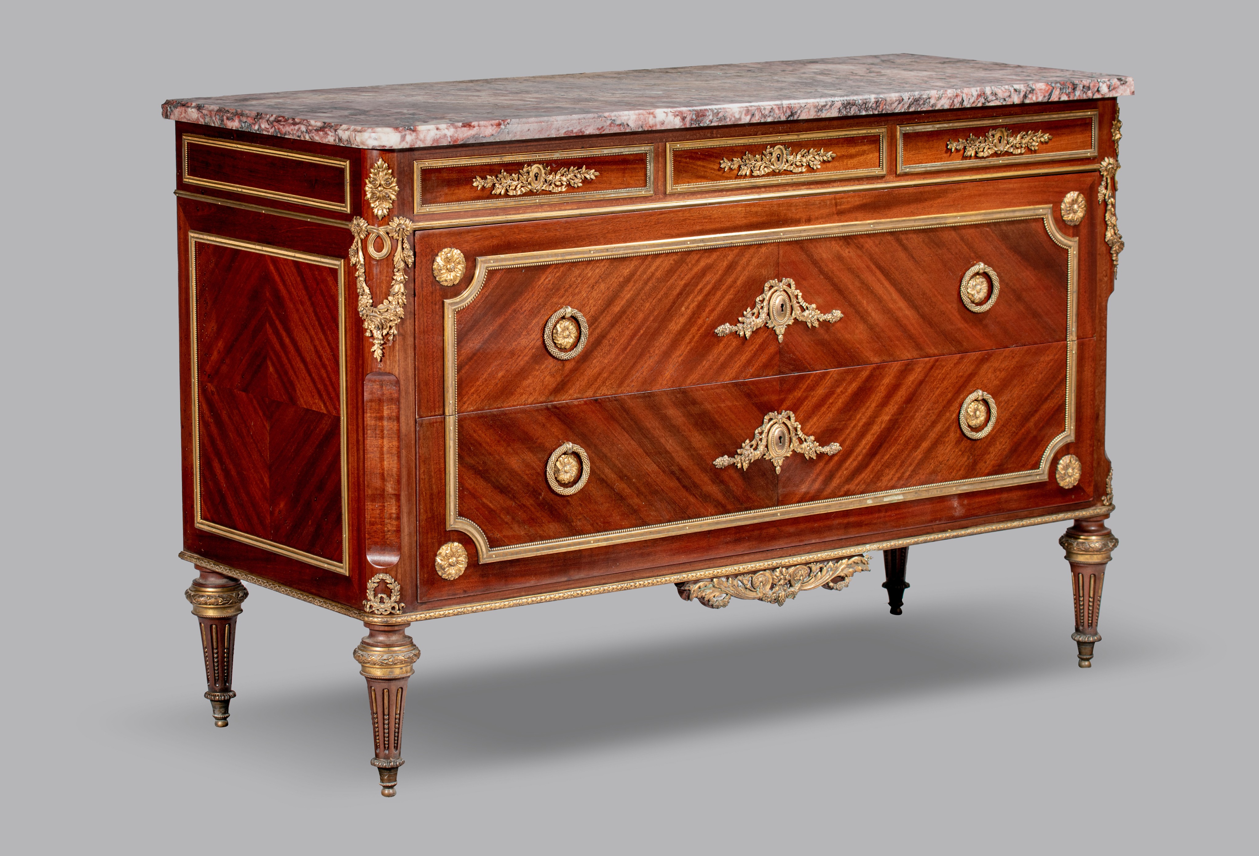 A Louis XVI style mahogany veneered commode with gilt brass mounts and marble top, H 89 - W 134 - D - Image 2 of 8