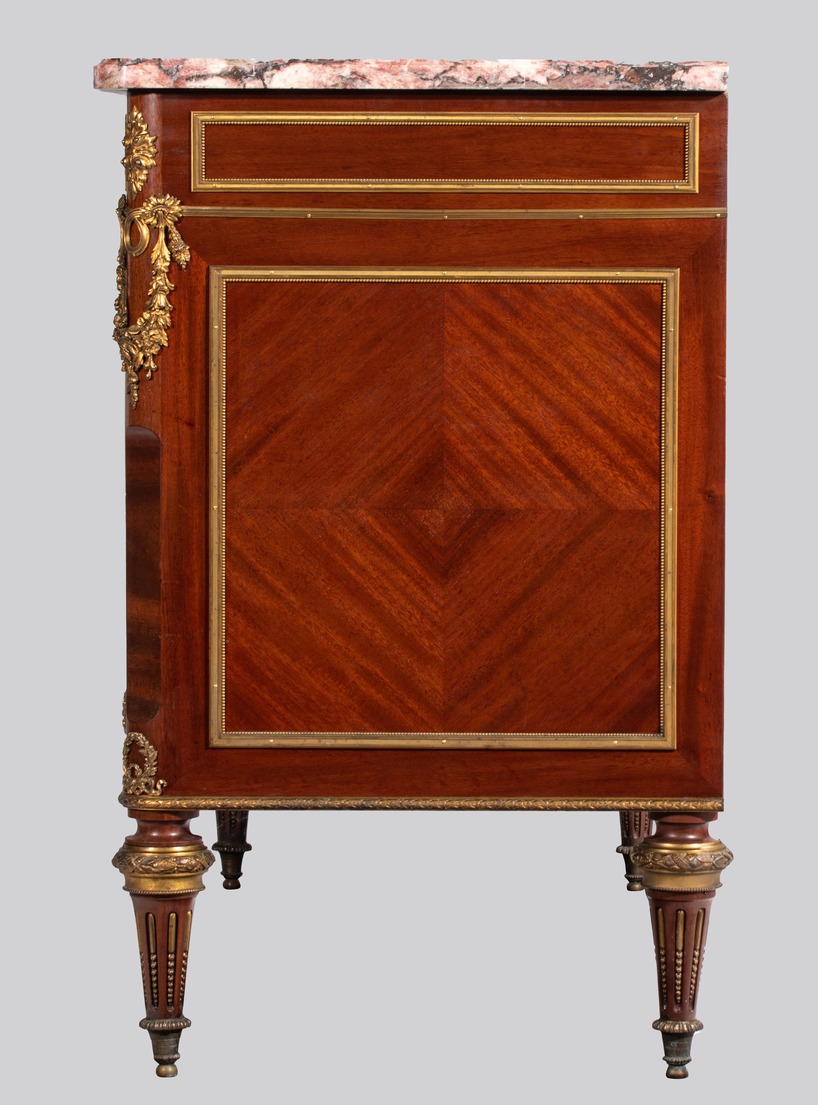 A Louis XVI style mahogany veneered commode with gilt brass mounts and marble top, H 89 - W 134 - D - Image 5 of 8