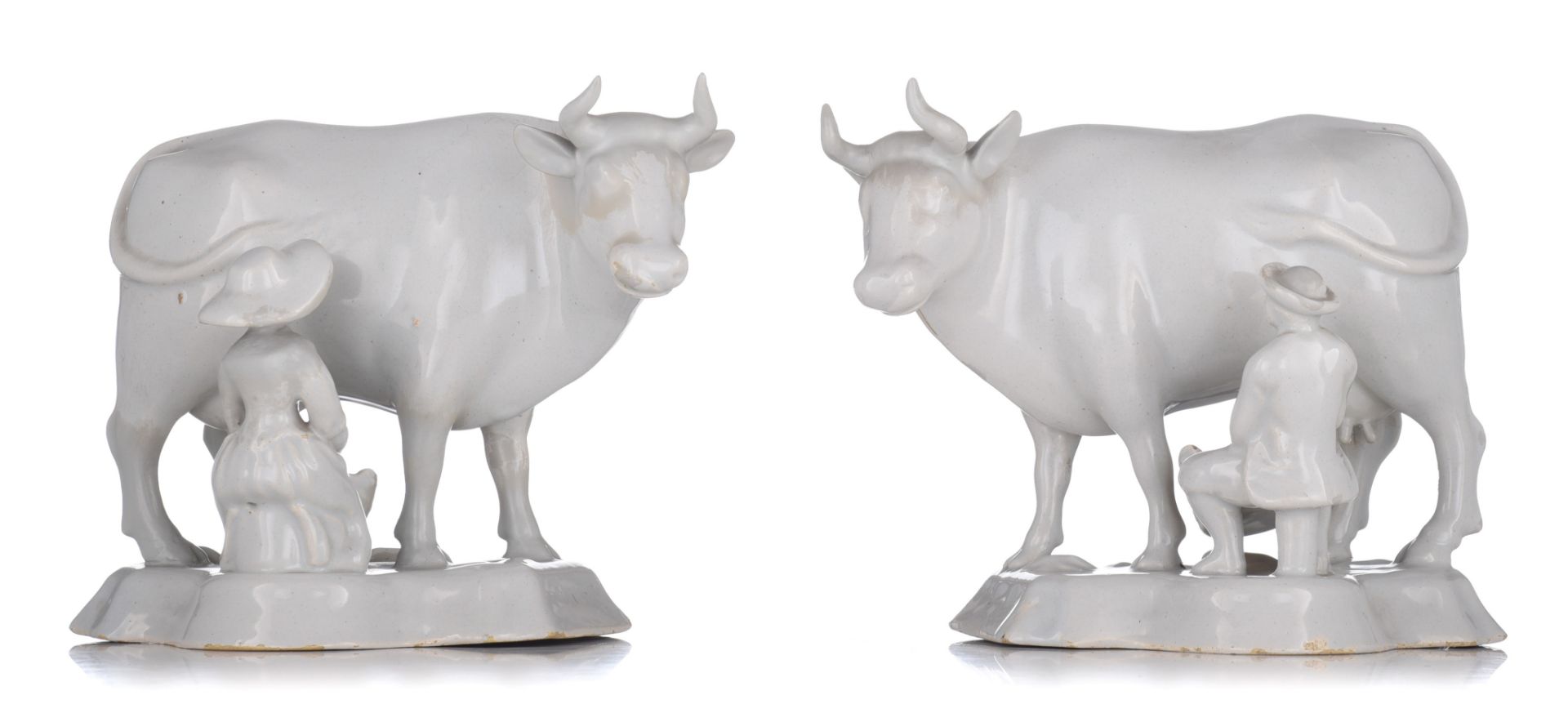 A large pair of Delft white-glazed models of cows with milkers, 18thC, H 18 - W 22 cm