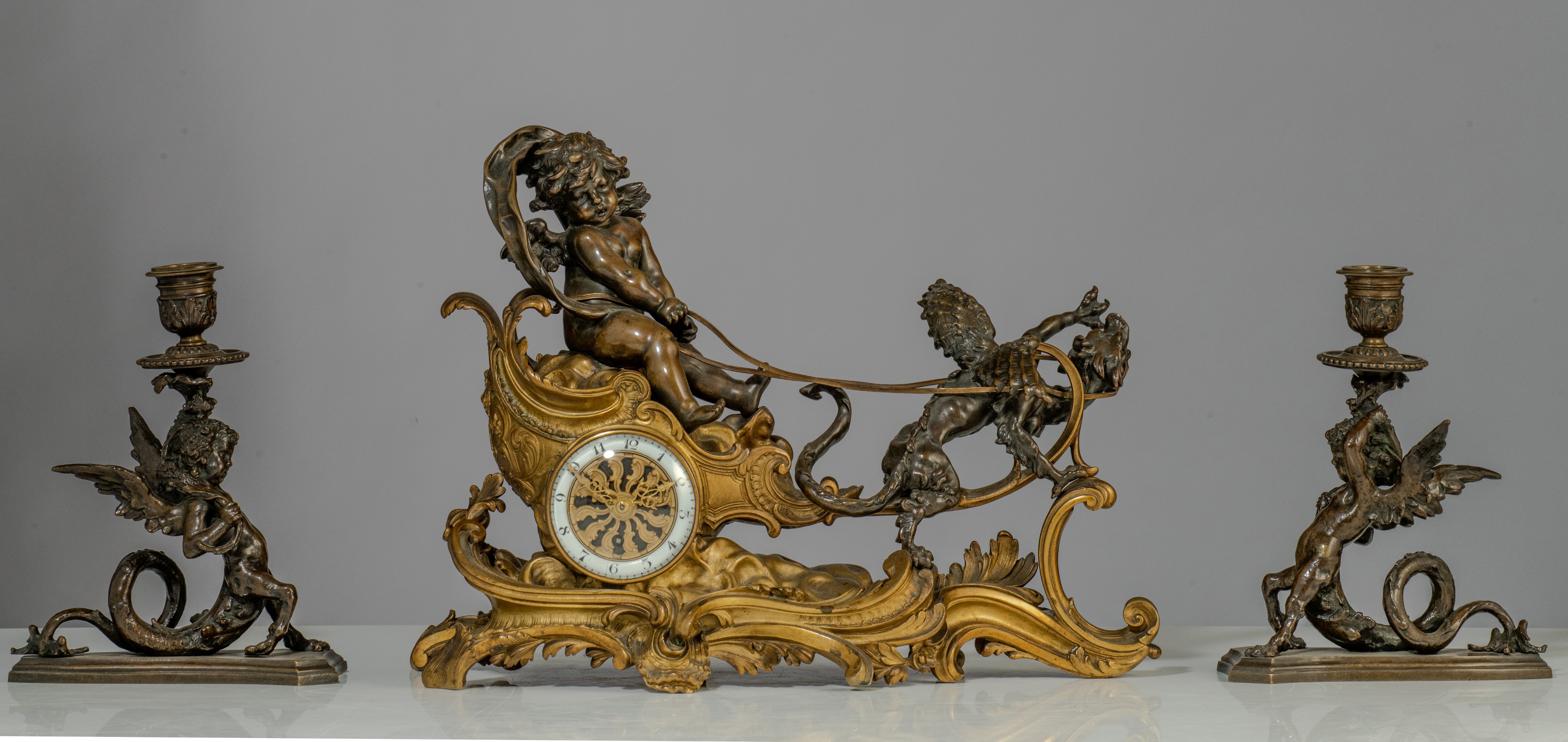 A Rococo style mantle clock with Cupid on his chariot and a pair of matching candlesticks, H 19,5 - - Image 2 of 9