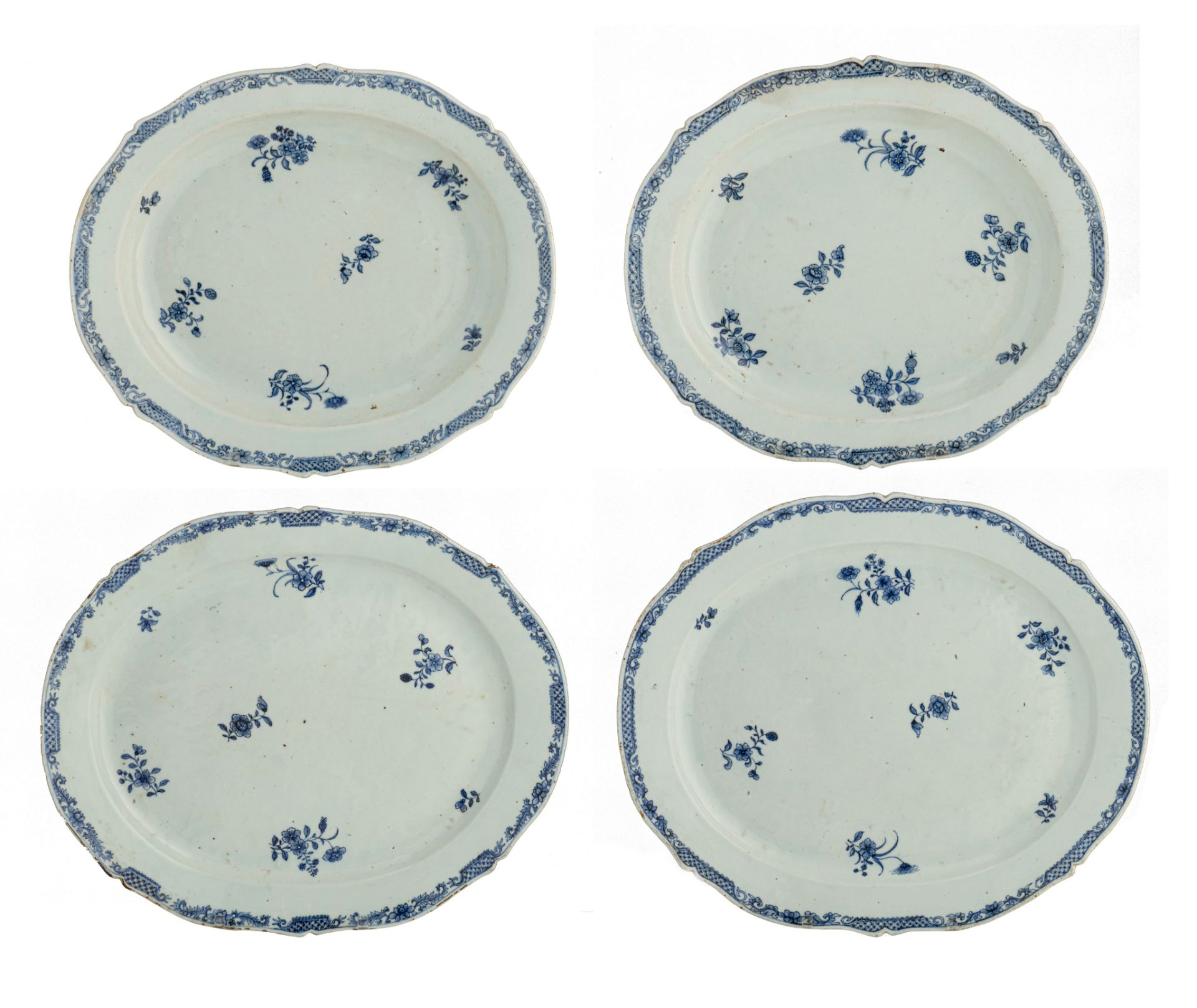 A series of four large Chinese blue and white floral decorated serving plates, 18thC, dia. 33 x 38,5