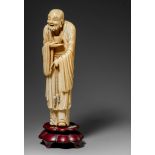 A Chinese ivory Daoist figure of a begging monk mounted on a hardwood base, Qing dynasty 18th/19th c