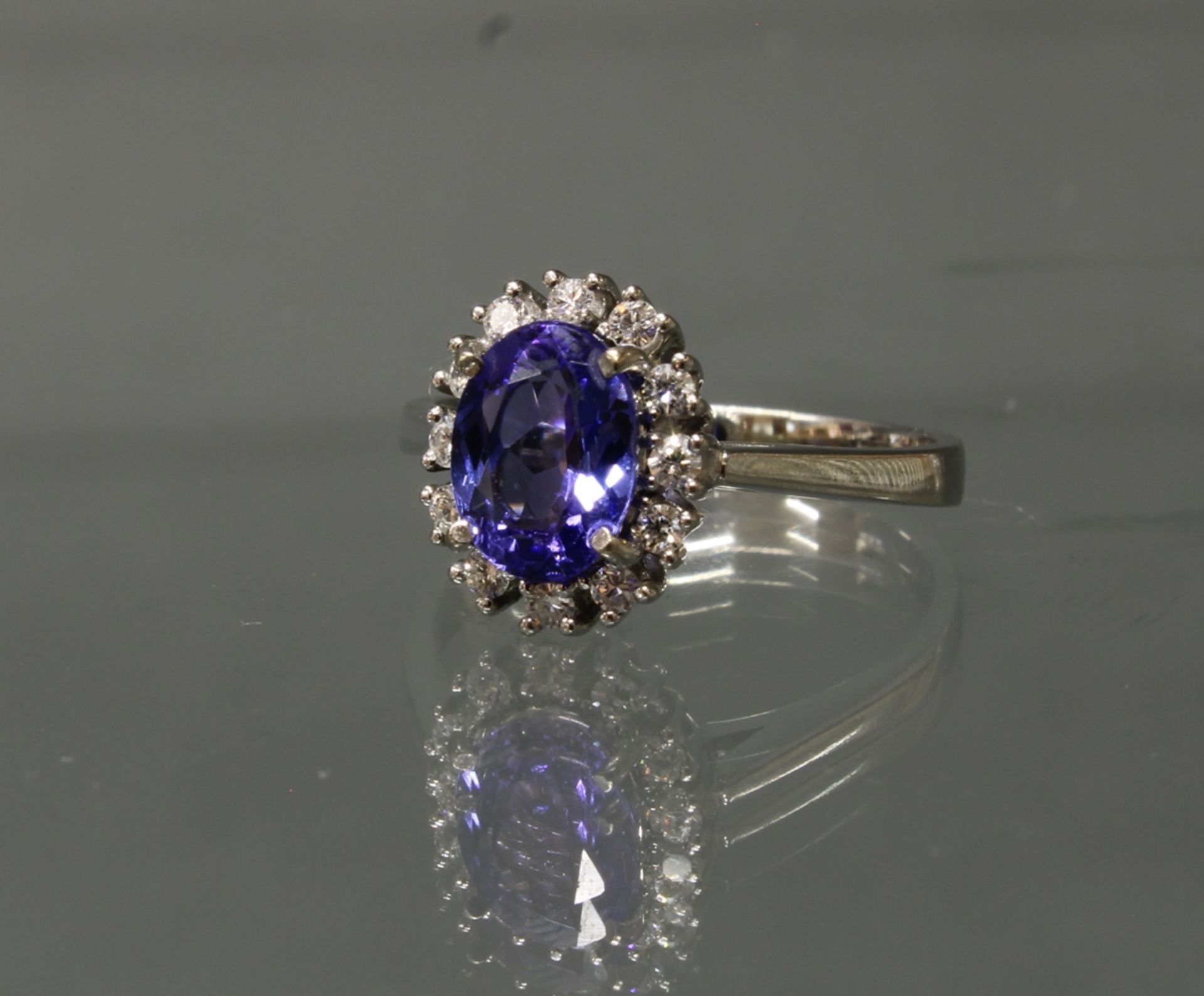 Ring, WG 750, 1 ovaler facettierter Tansanit ca. 1.80 ct., 12 Sechzehnkant-Diamanten zus. ca. 0.30 