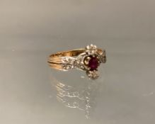 Ring, um 1900, RG 750, teils weiß belötet, 1 runder facettierter Rubin ø ca. 4.5 mm, 2 Diamanten zu