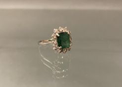 Ring, WG 750, 1 rechteckig facettierter Smaragd ca. 9 x 8 mm, starke Einschlüsse, 12 Brillanten zus