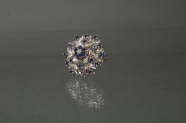 Brosche, WG 750, 1 Brillant ca. 0.05 ct., 24 kleine runde facettierte Saphire, 9 g