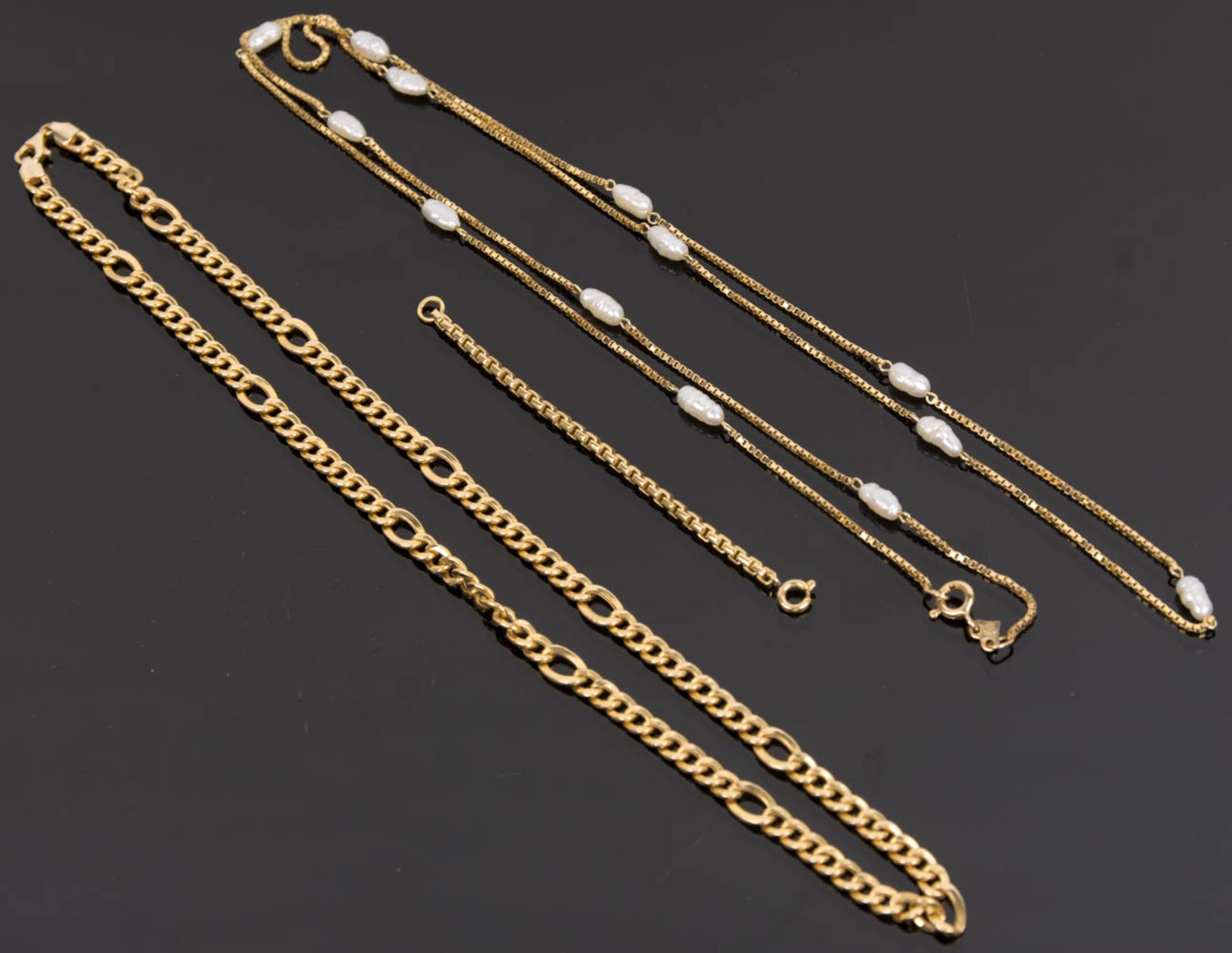 Konvolut von zwei Halsketten und einem kurzen Kettchen, 585er und 750er Gelbgold.