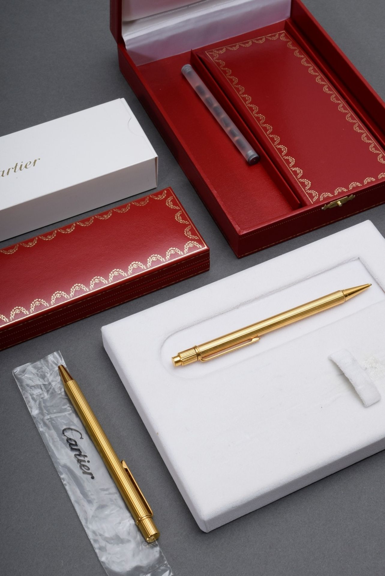 2 Cartier Schreibgeräte „Le Must de Cartier“: Kugelschreiber und Druckbleistift, vergoldet, in Orig