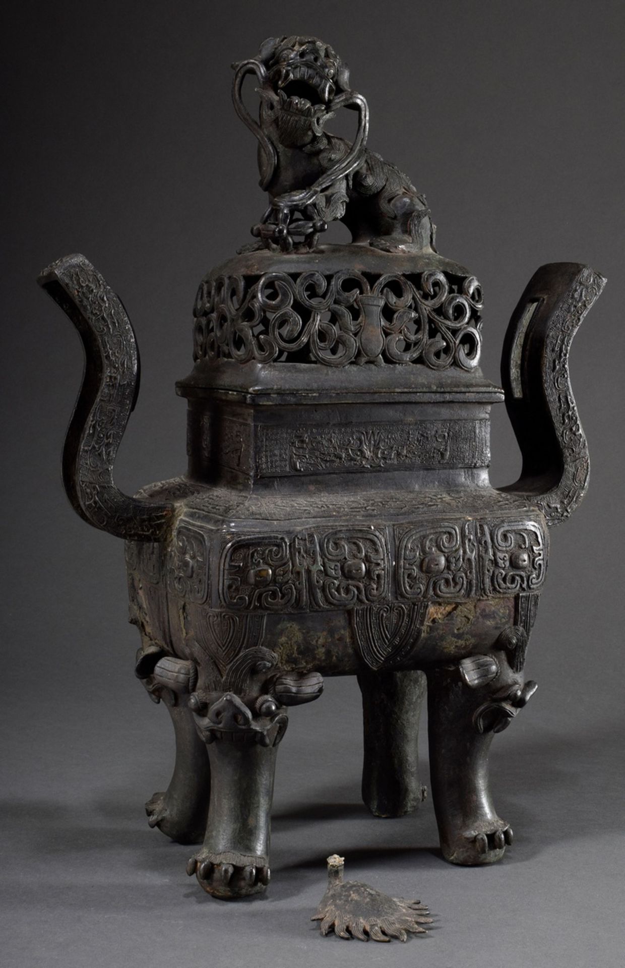 Large angular bronze lidded koro with archaic reliefs paw feet and fo-lion knob, China Qing period,