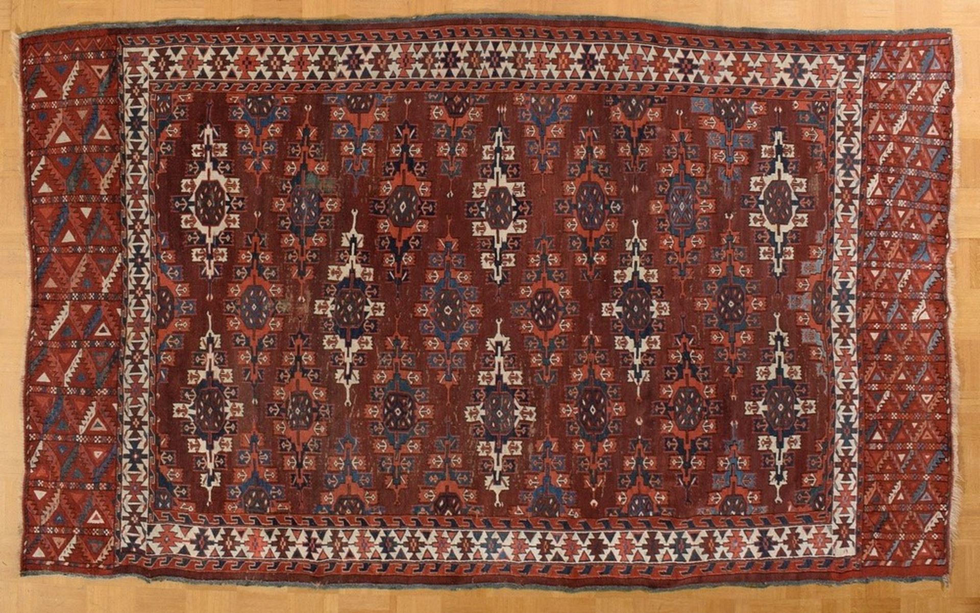 A Yomud main carpet with flat kepse güls arranged in offset colours, a white-ground main border wit