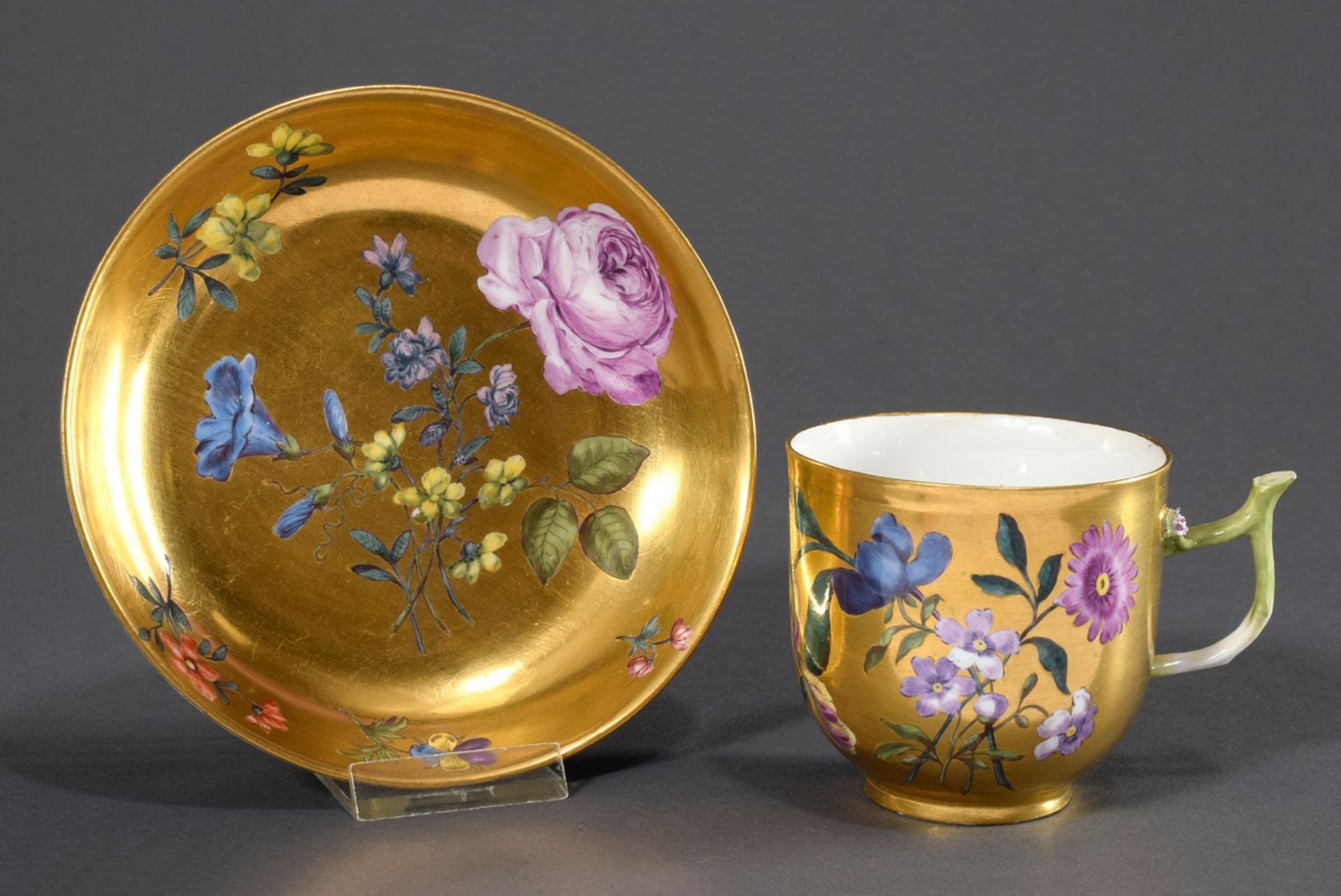 Meissen cup with polychrome bouquet and scattered flower painting on gold background and branch han