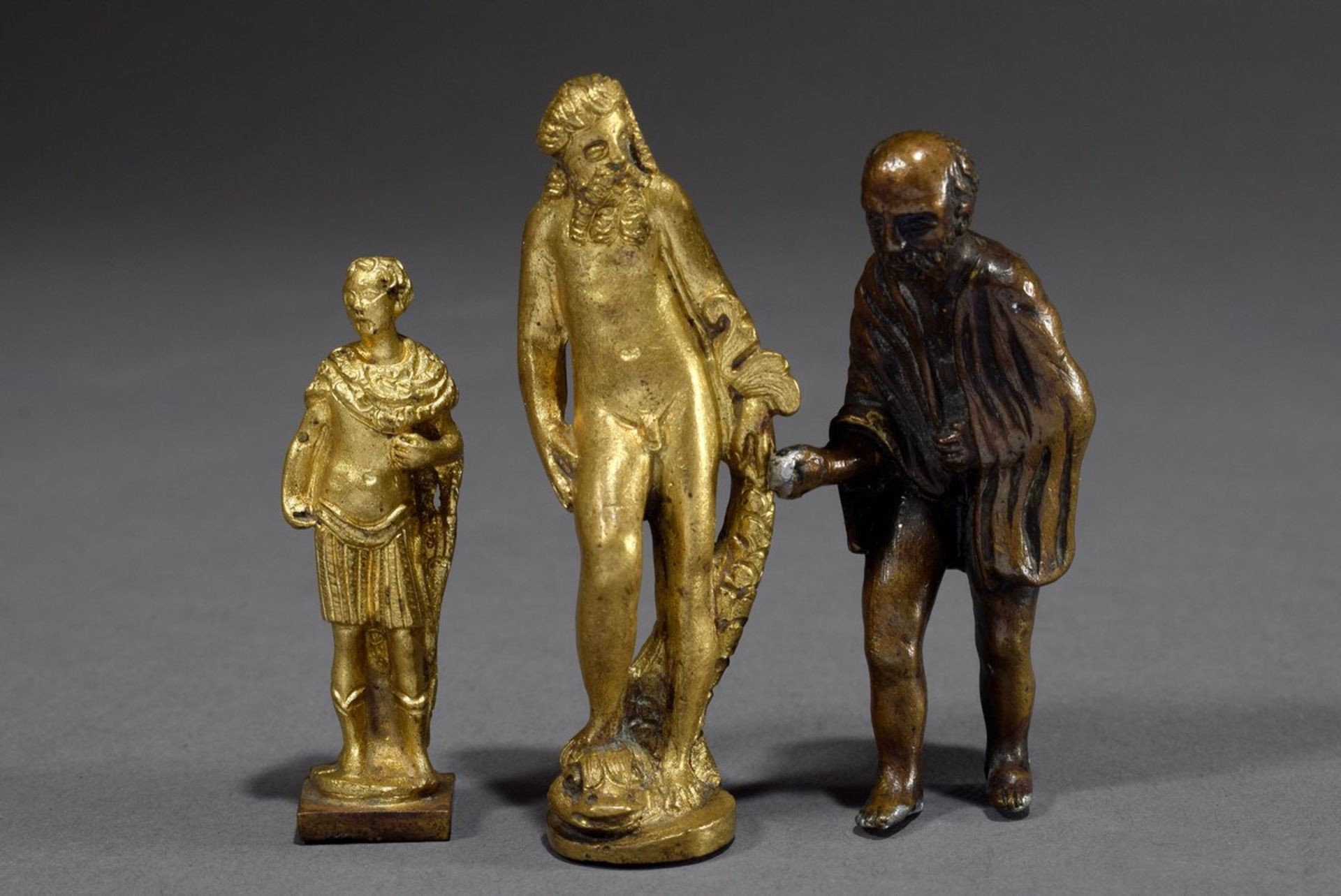 3 Various mythological yellow and red brass miniatures: "Sea god with fish", "Roman" and "Beggar wi