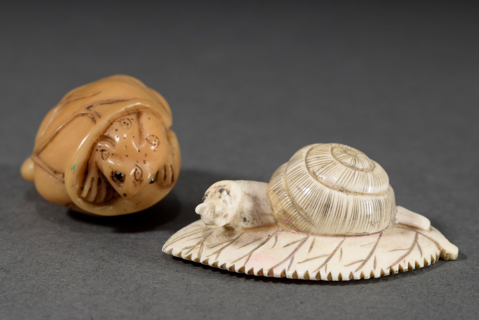 2 Various netsukes: bone "snail on leaf" (h. 1,5cm) and dayanut "frog in lotus leaf" (h. 2cm), sign