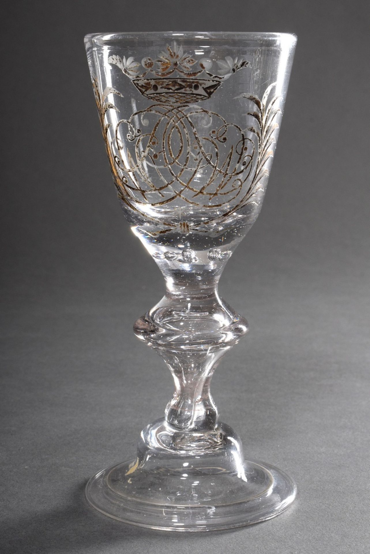 Baroque goblet glass on a bell base with turned rim, hollow blown baluster stem with 7 pierced bubb