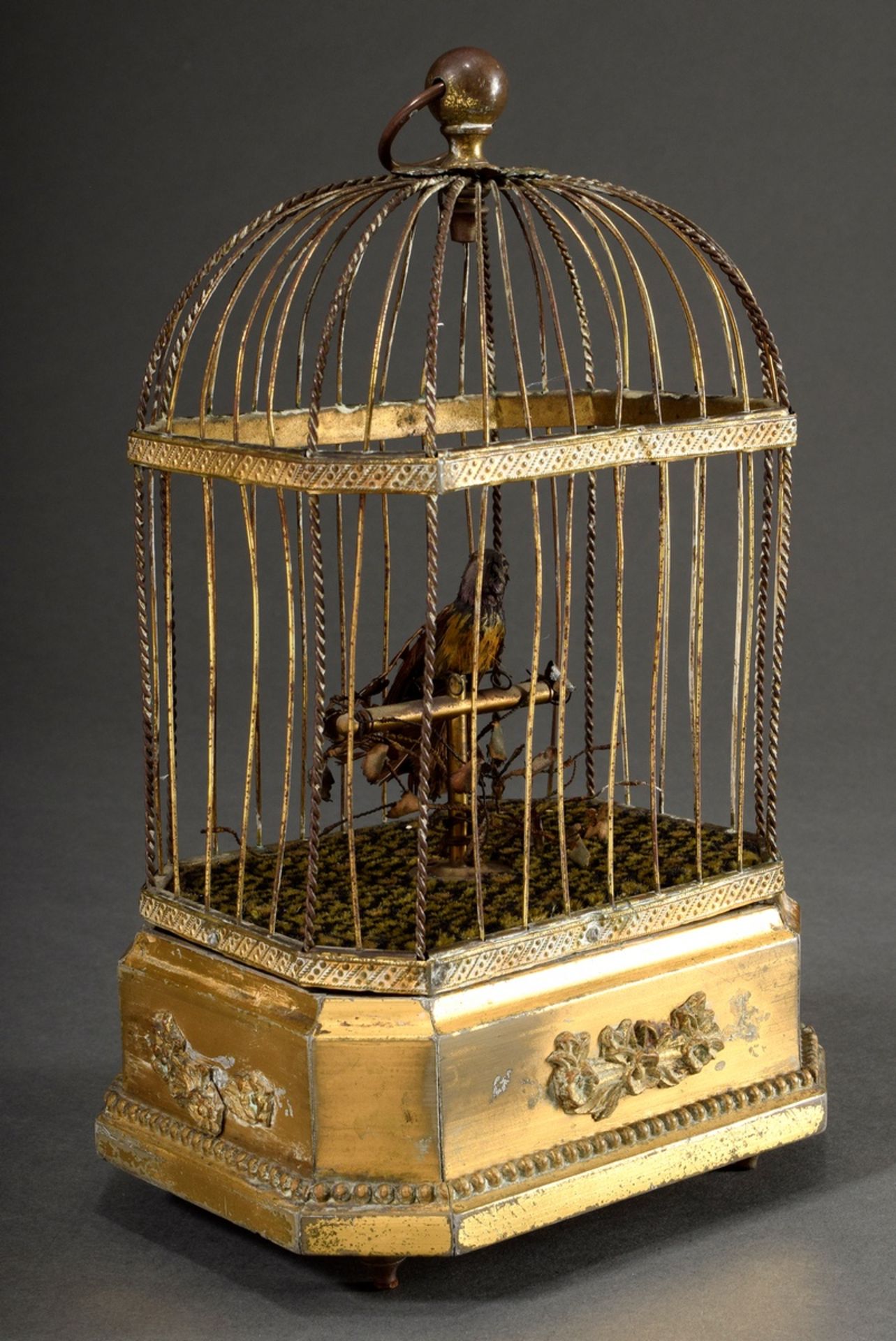 Singing bird automaton with small feathered bird on rod in brass wire cage on gilded wood base with