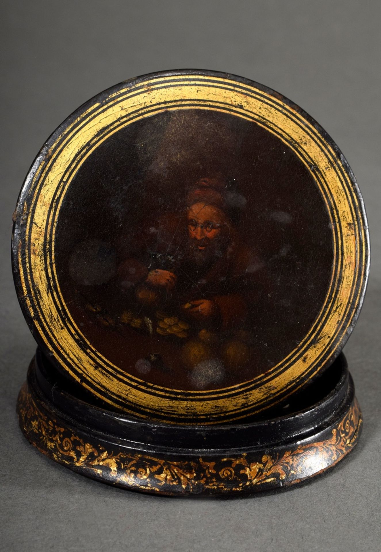 Round lacquer box with fine painting "money counter" on the lid and gold staffage, probably Stobwas