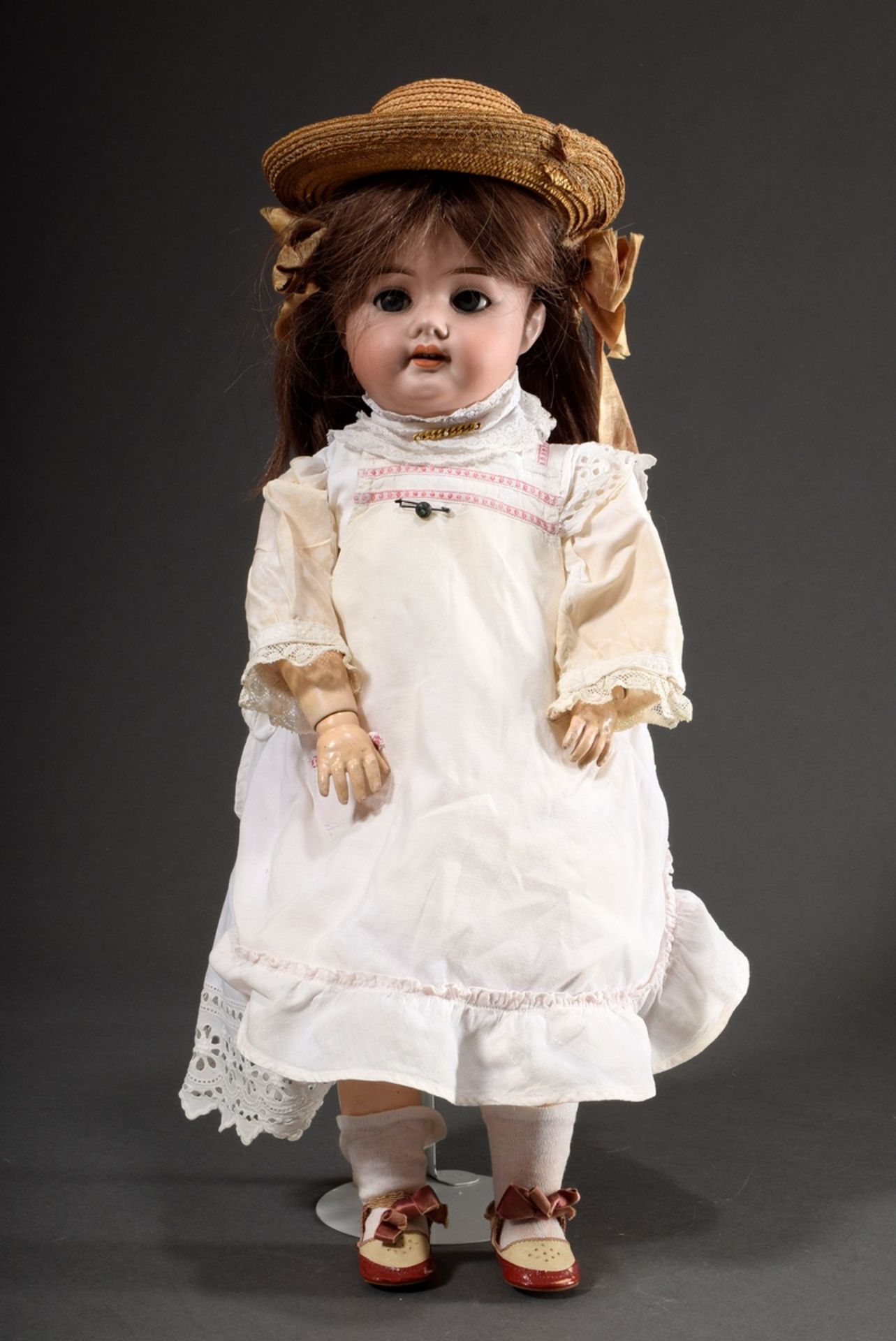 Doll with porcelain crank head and wooden/mass jointed body, brown human hair wig, blue glass eyes,