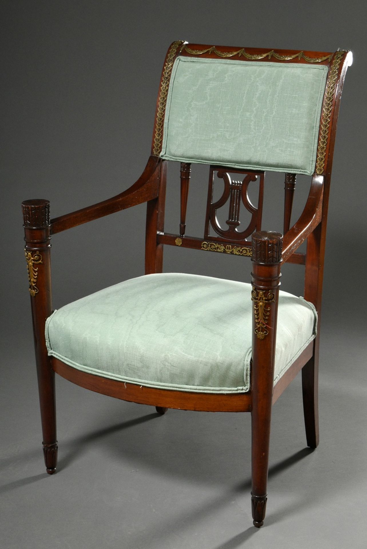 Elegant mahogany armchair in Empire style with fire-gilt fittings and carved lyre in the backrest a