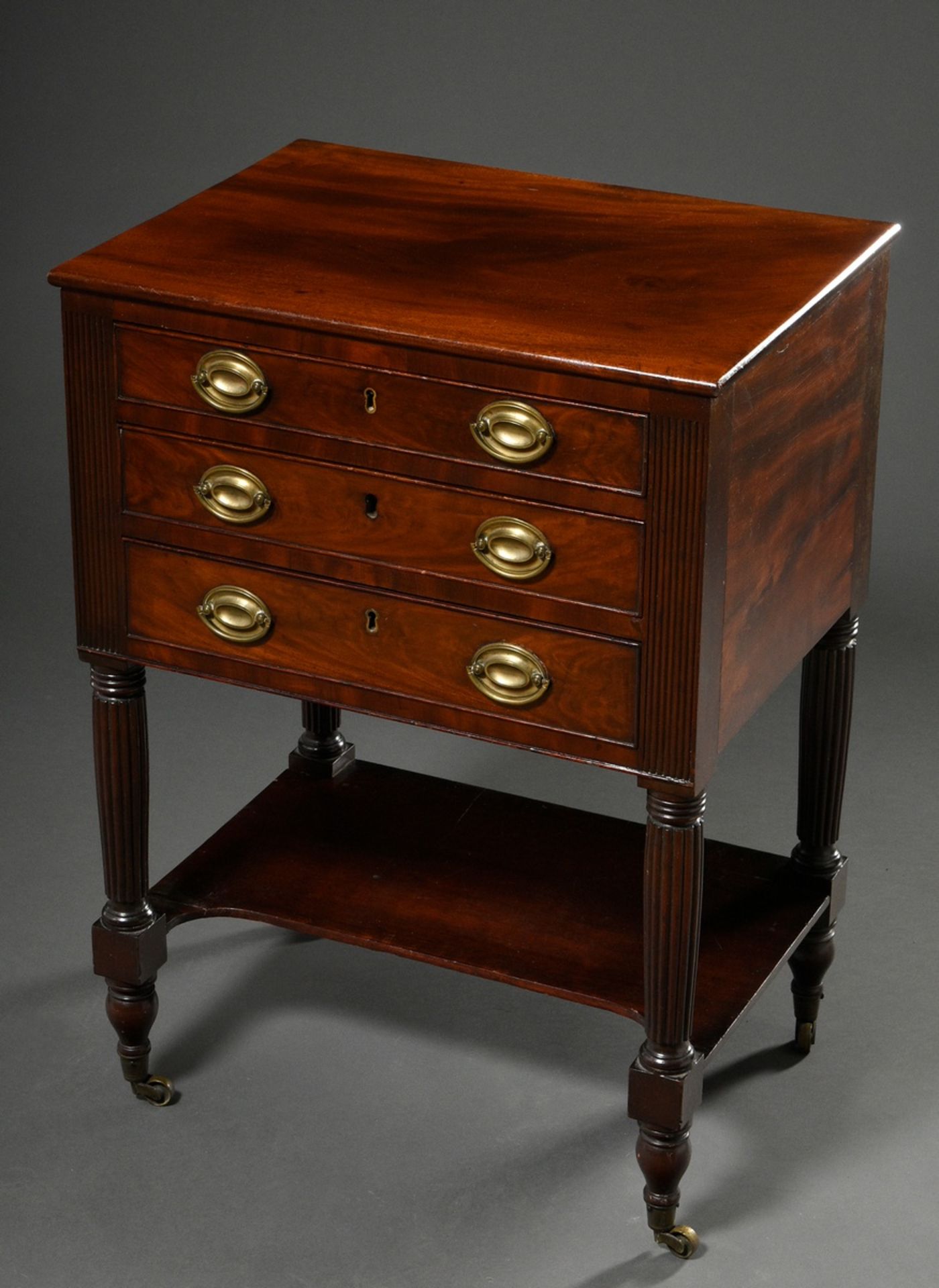 Three-bay occasional furniture on fluted legs with pull-out writing drawer and punched leather top,
