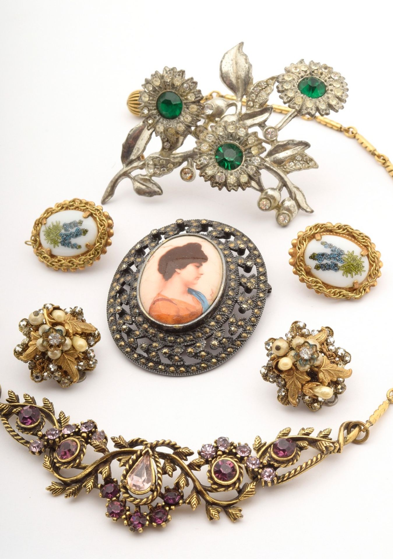 7 pieces of costume jewellery, gold plated and in white metal with rhinestones, plastic and artific