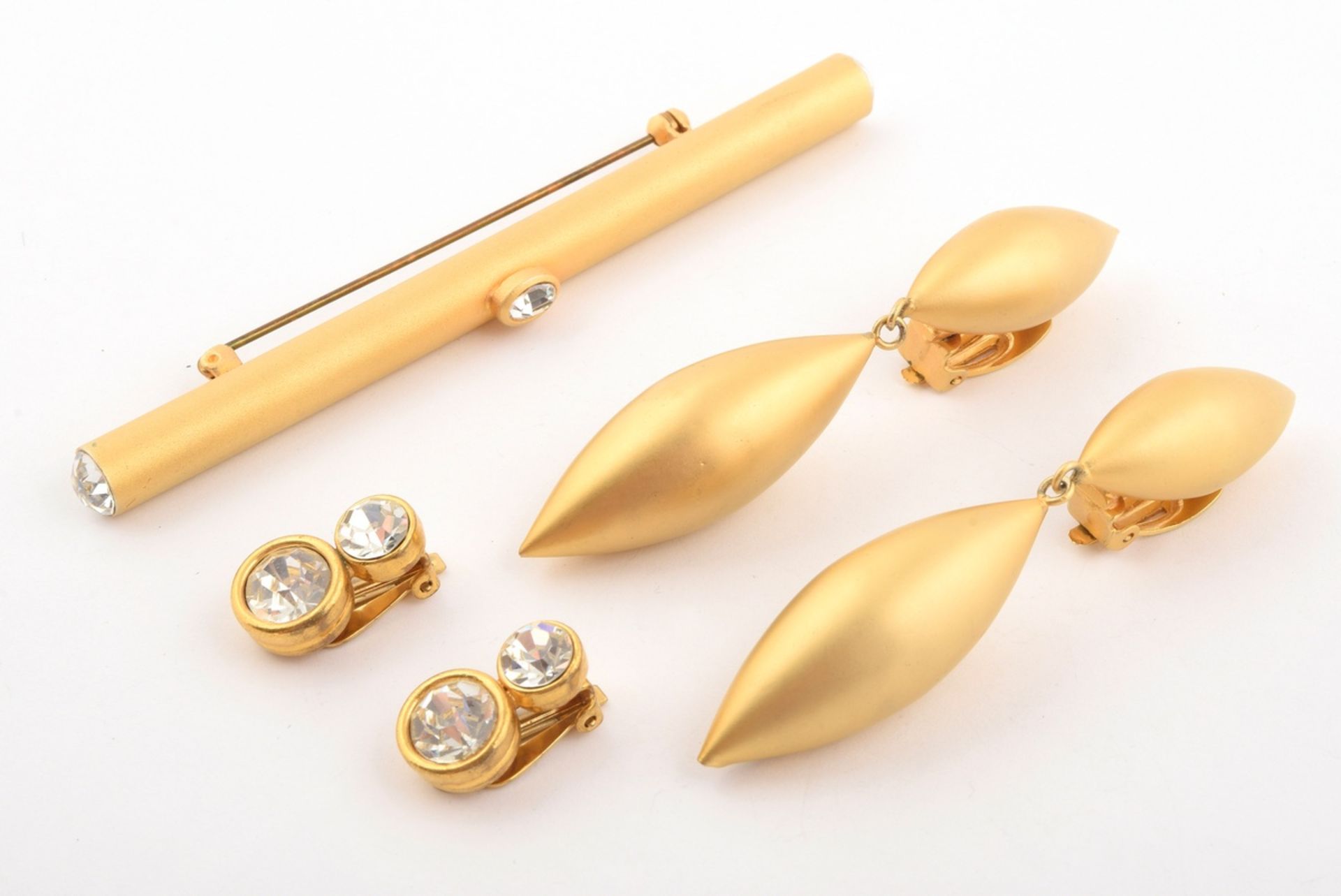 4 pieces of gold plated modern costume jewellery with rhinestones: 1x pin (l. 10,5cm), 1x pair of e