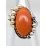 Ring mit Korallen-Cabochon, 11 Perlen und 3 Brillanten, zus. ca. 0,09 ct, 90- er Jahre.