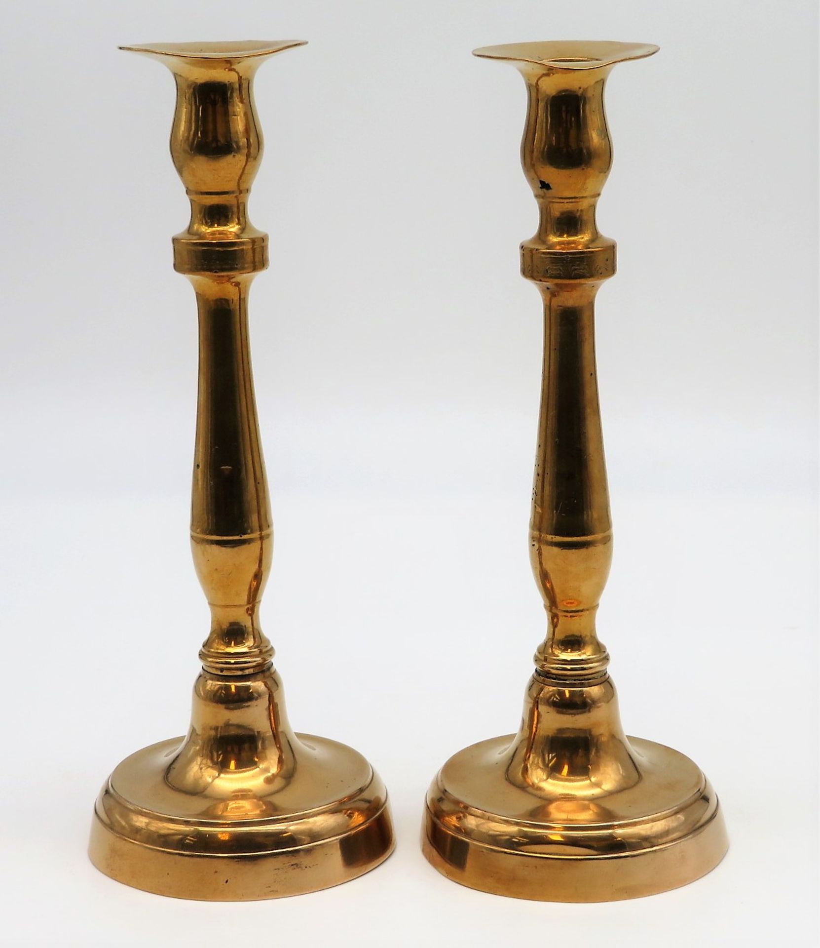 2 Kerzenleuchter, Mitte 19. Jahrhundert, Messing, Füße leicht gedellt, h 23 cm, d 8,5 cm.