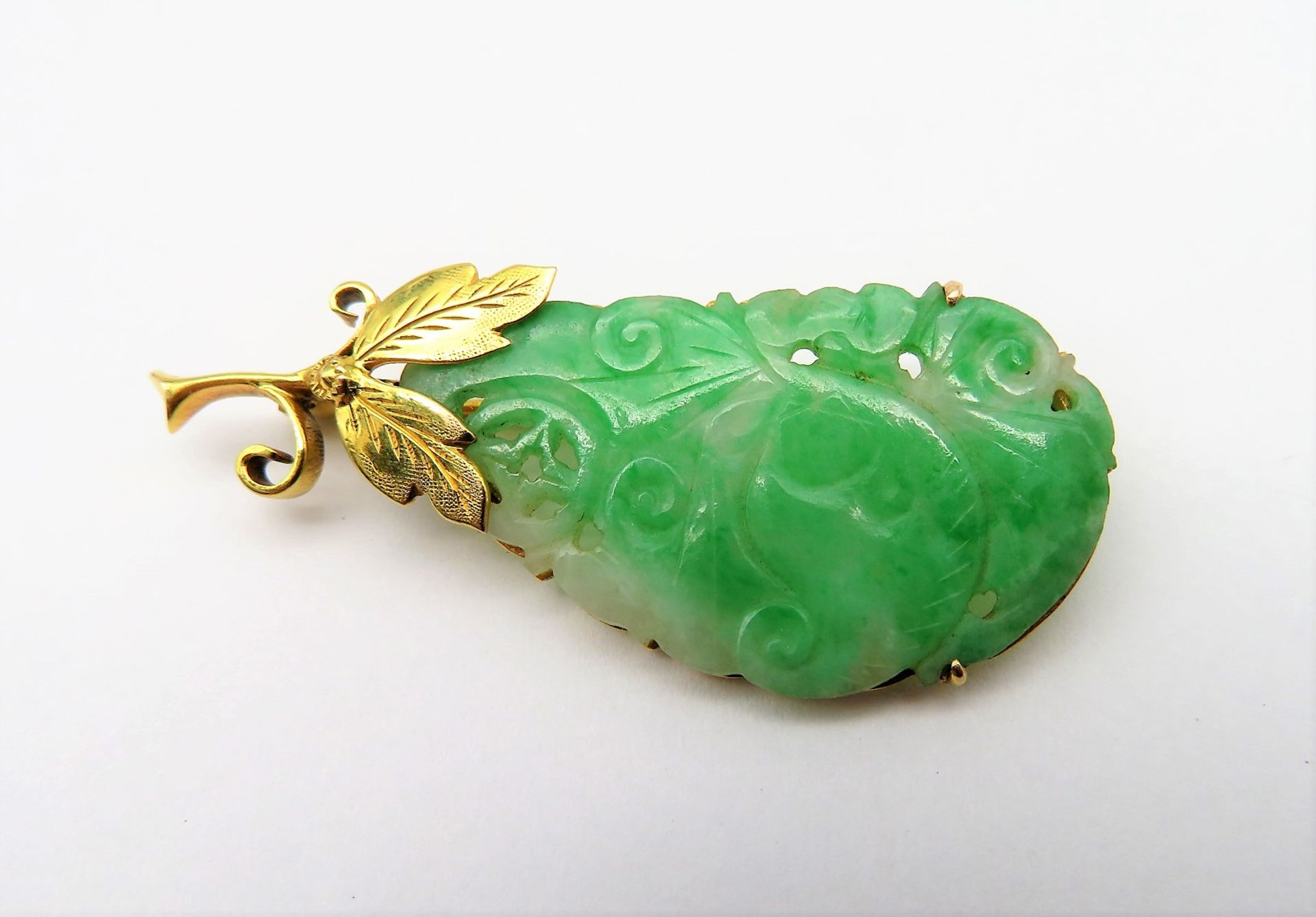 Brosche, grünlich-weiße Jade fein geschnitzt, 585er Gelbgoldfassung, gepunzt, 5,1 g, 4,5 x 2 cm.