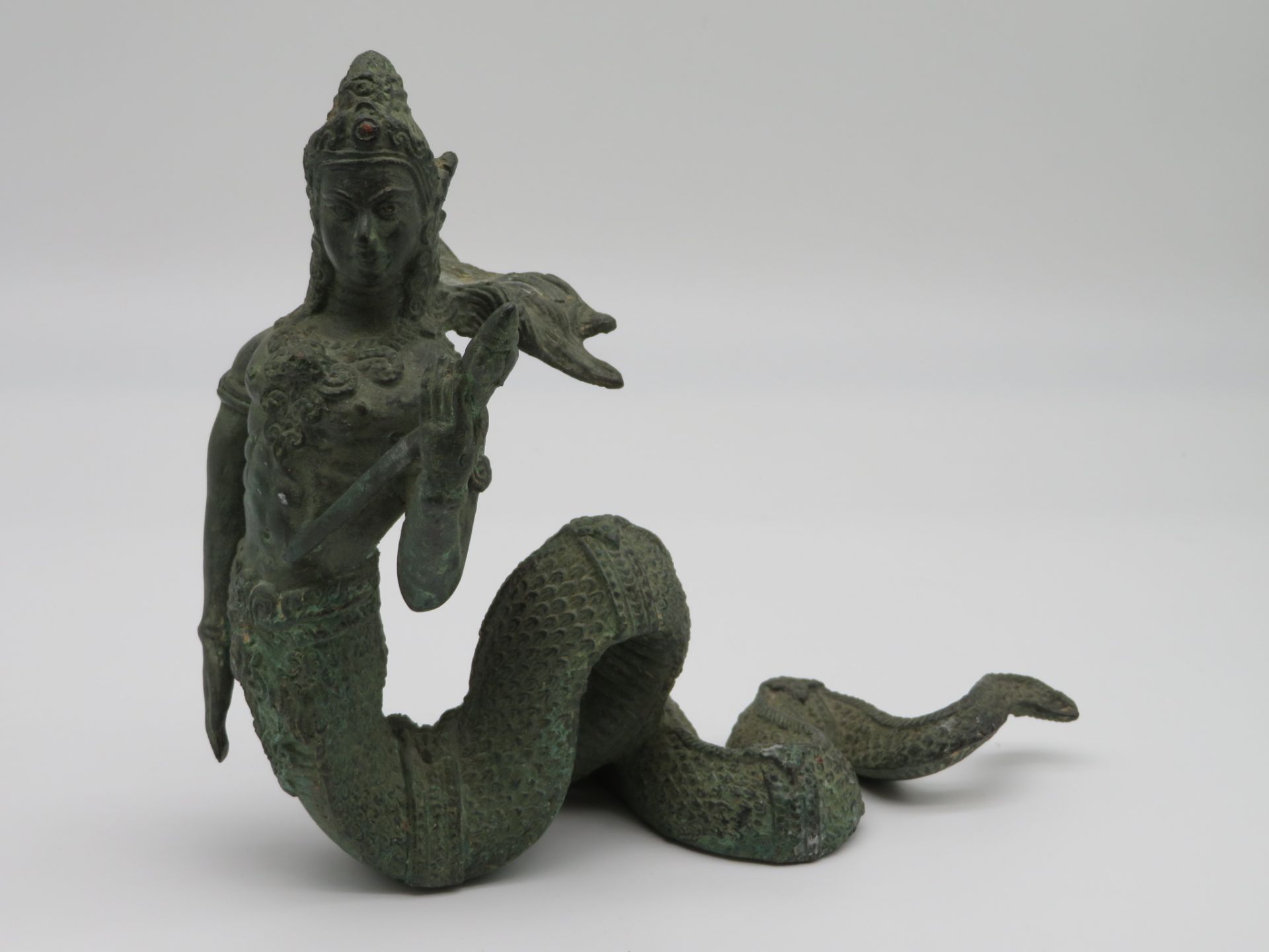 Schlangengöttin, wohl Indien, Bronze grünlich patiniert, 20 x 23 x 11 cm.