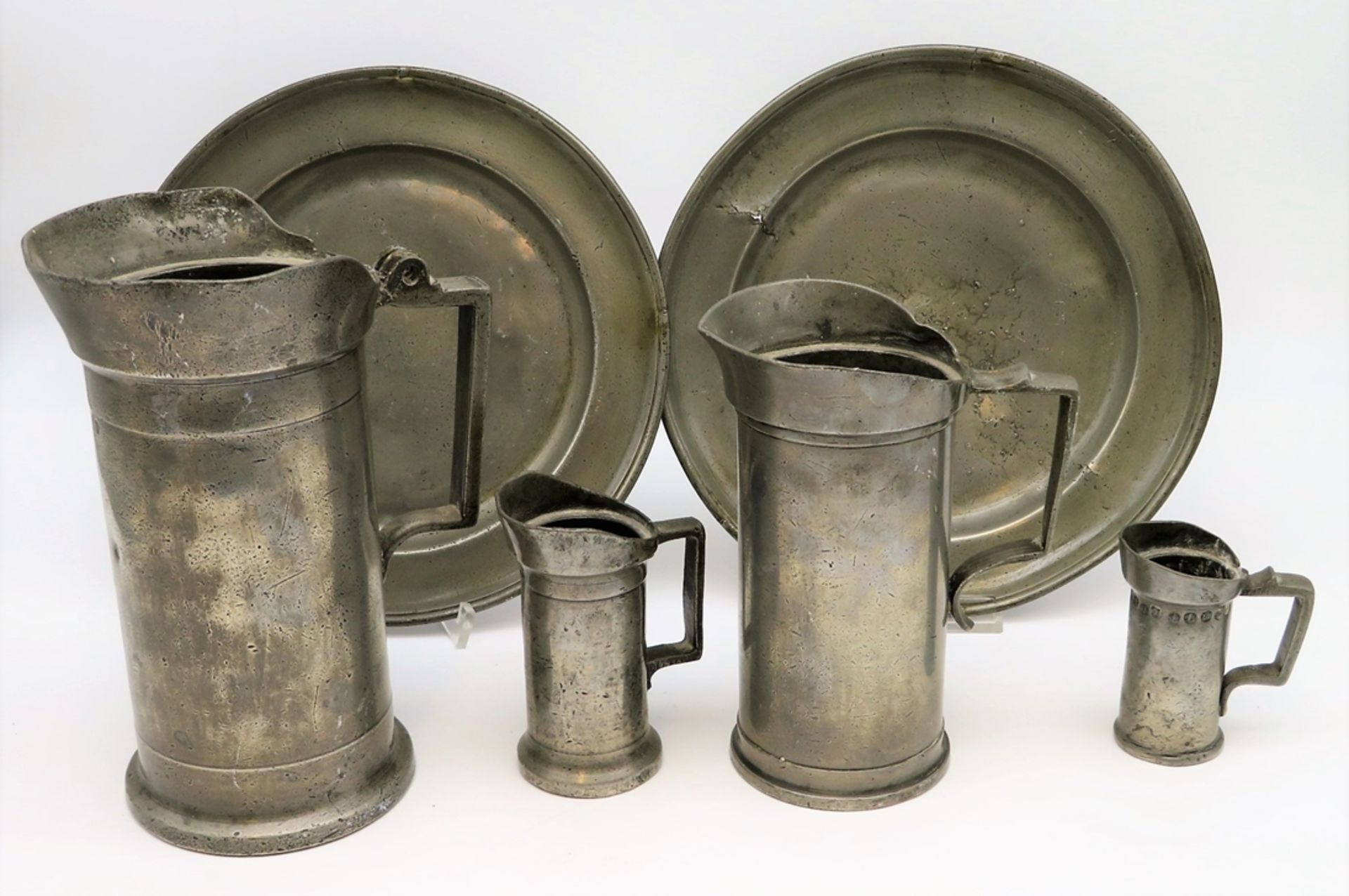 4 antike Maßbecher und 2 Teller, 1. Hälfte 19. Jahrhundert, Zinn, 1 x Deckel fehlt, altersbedingte 