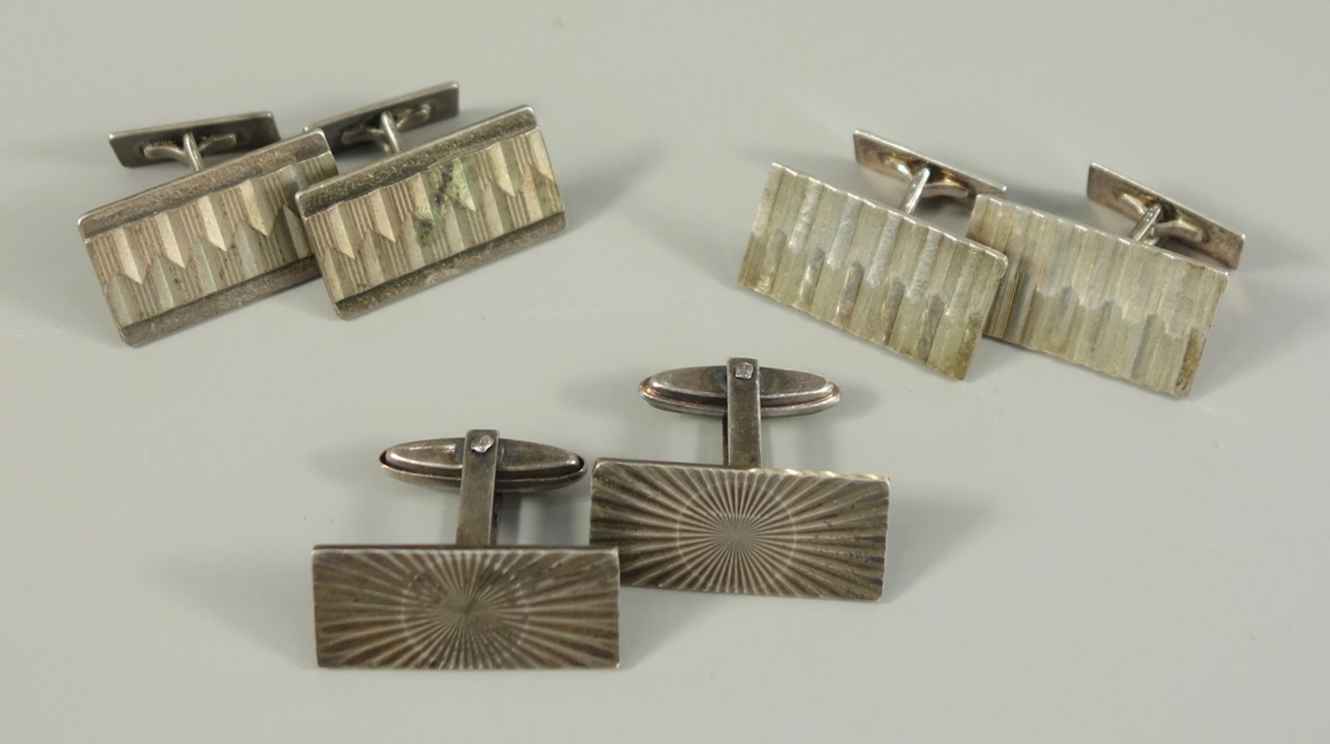 3 pairs of cufflinks, 835 silver, weight 28.55 g, rectangular plates with different, geometric engr