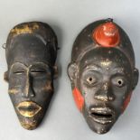 Afrikanische Masken, zwei Stück, 20. Jh., Holz geschnitzt , geschwärzt und bemalt, L 31 cm