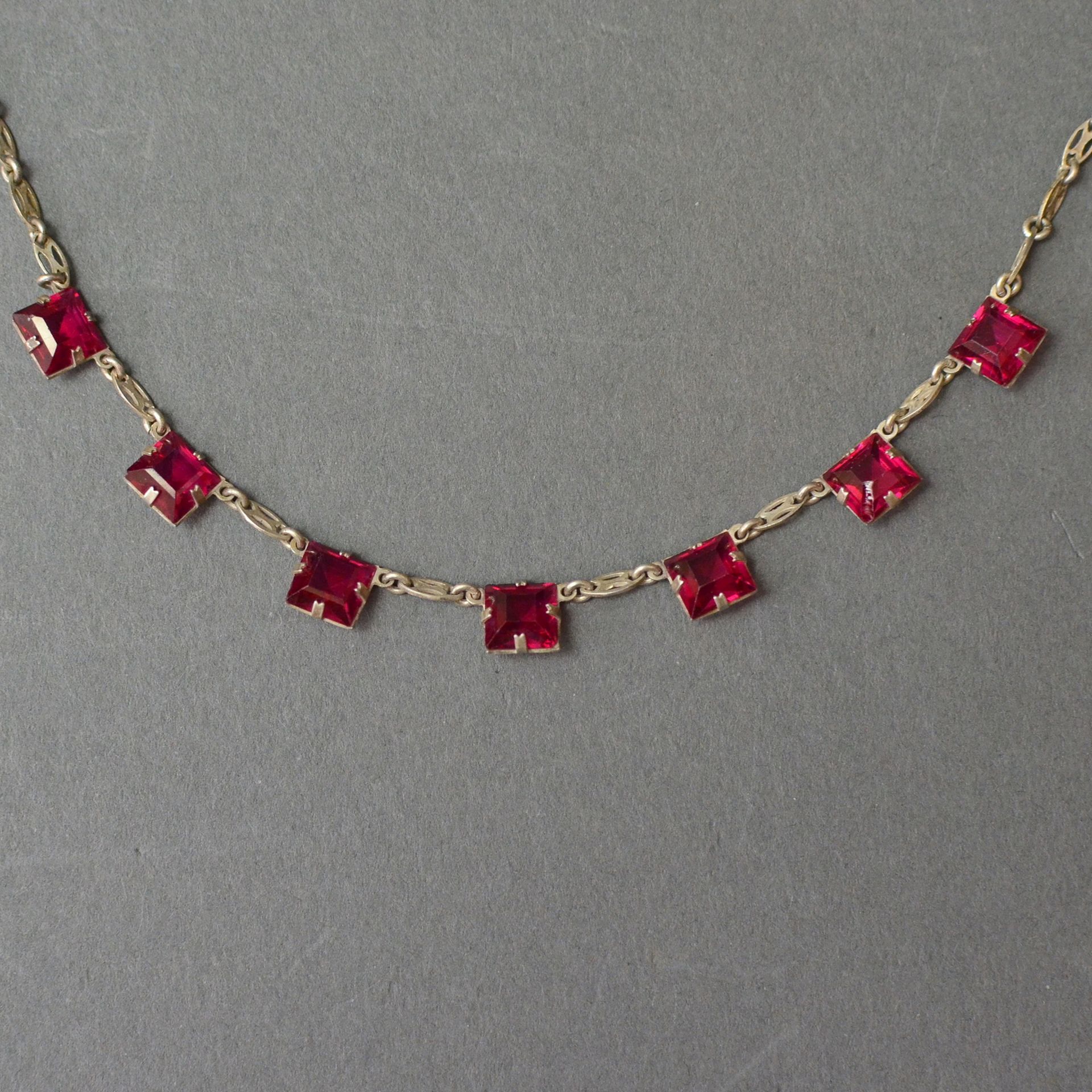 Art-Deco Collier, Silber punz. 830, mit 7 roten facettierten Steinen im Quadratschliff, L 40cm