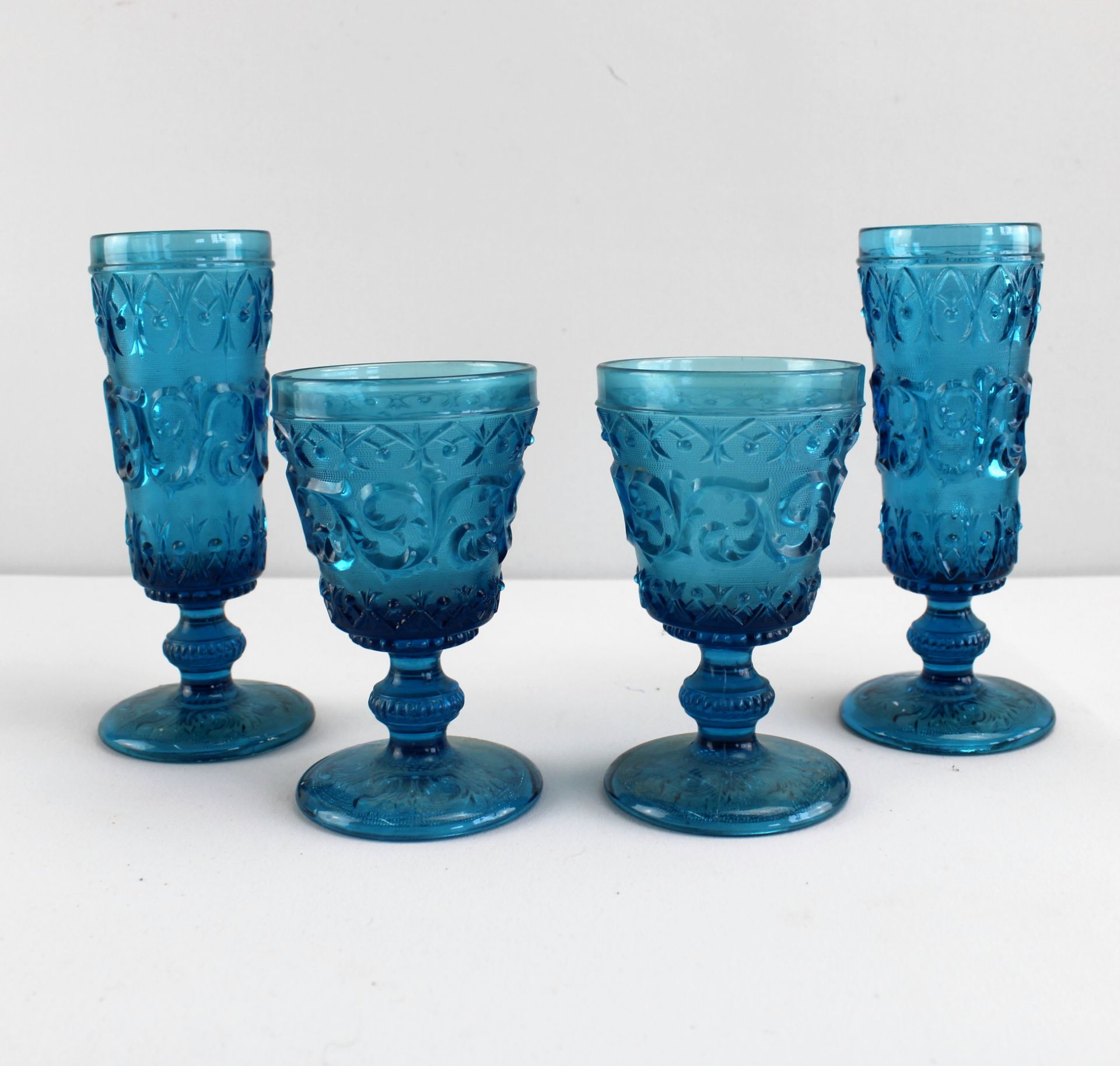 4 Historismus-Becher, um 1880, blaues Pressglas, reliefiertes Rankendekor