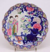 Asiatischer Teller mit zwei Frauenfiguren und floralen Motiven, D. 24,5 cm