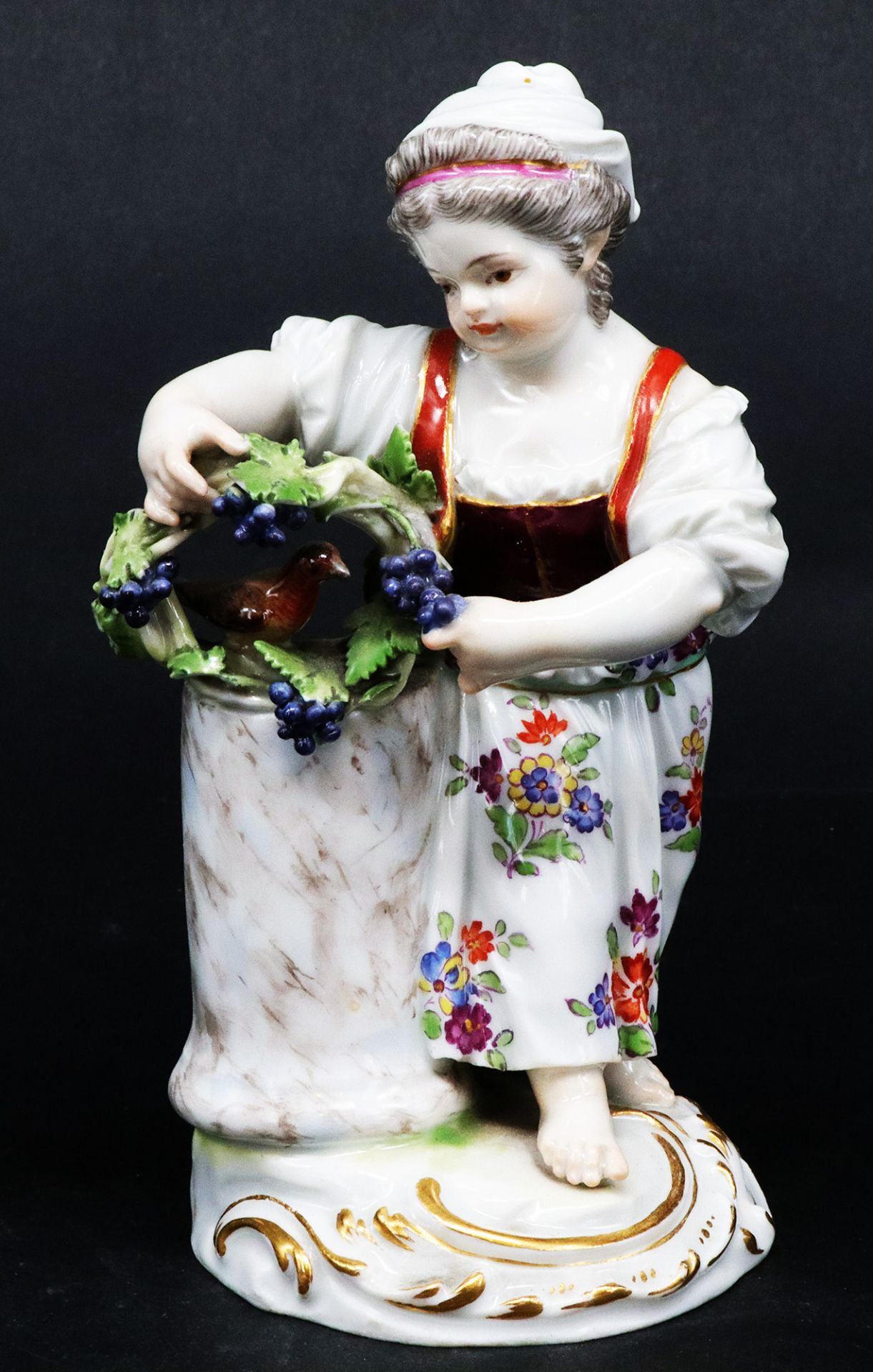 Meissen, Gärtnerkind, Porzellan, um 1920, farbig staffiert. Mädchen an Säule gelehnt mit Blumenkranz