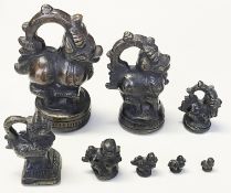 8 Gewichte, Sri Lanka, Bronze, H. zw. 1,5 und 12,5 cm. Zugabe: Bucklige Katze, H. 5 cm