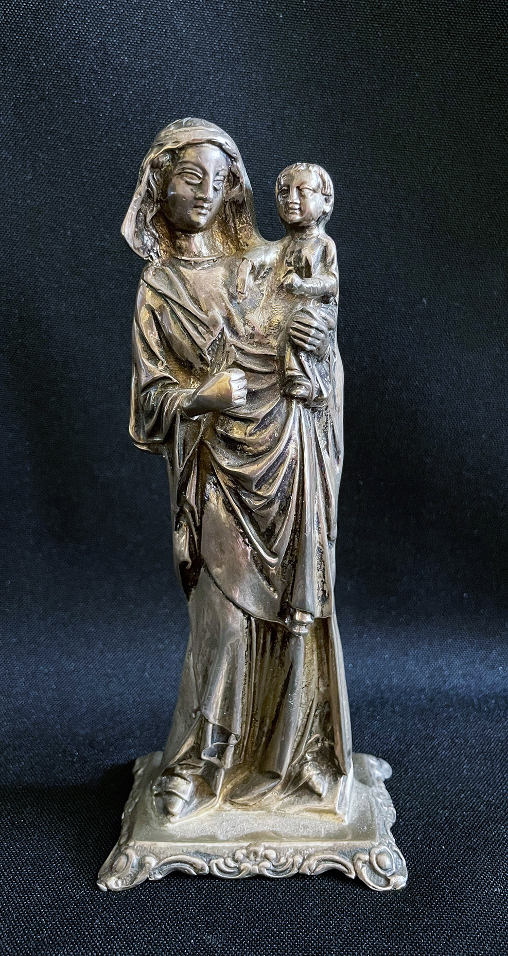 Madonna, 800er Silber, H. 15,5 cm, 188,7 g. Auf rechteckiger Plinthe Maria, den Jesusknaben auf
