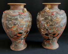 Paar Satsuma-Vasen, Japan, polychrom und gold bemalt, figürliche Szenen sowie Drachen im Hochrelief,
