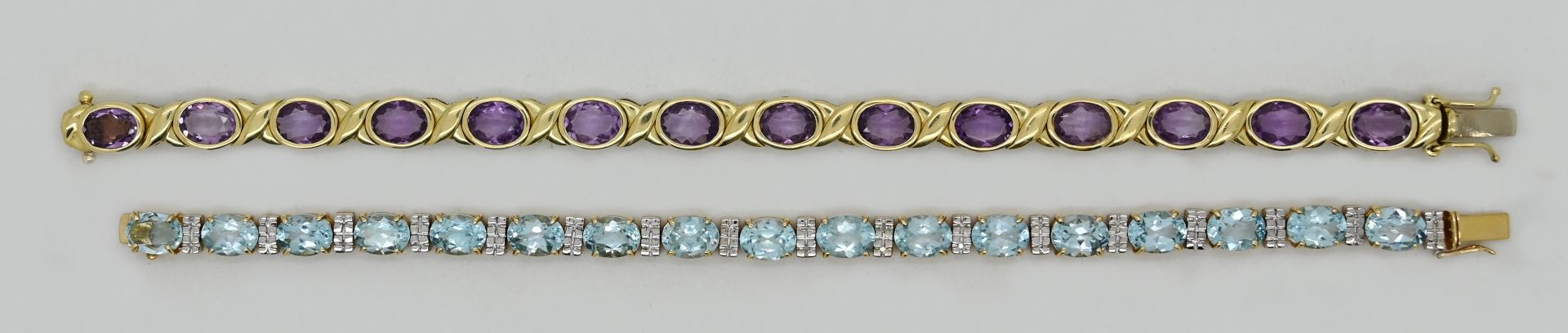 2 Damenarmbänder jew. GG/ WG 14ct. z.T. mit Amethysten, wohl Blautopase, Tsp.